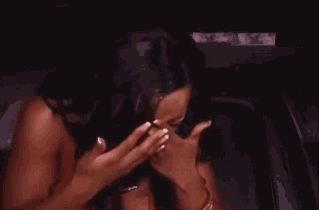 a woman is crying in a car while sitting in the back seat .