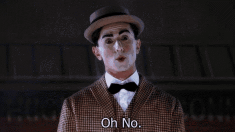 a man in a suit and hat with white paint on his face is saying `` oh no '' .