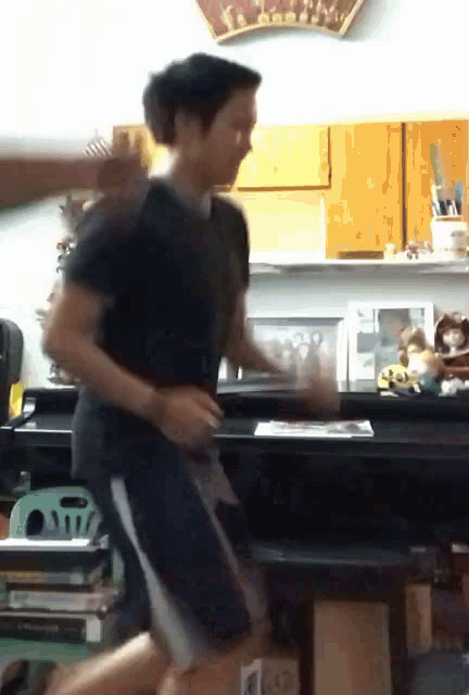 a man in a black shirt and white shorts is running