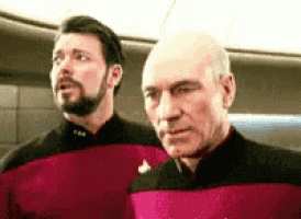 two men are standing next to each other in a room .