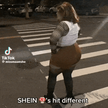 a woman is standing on a crosswalk with the words shein 's hit different on the bottom right