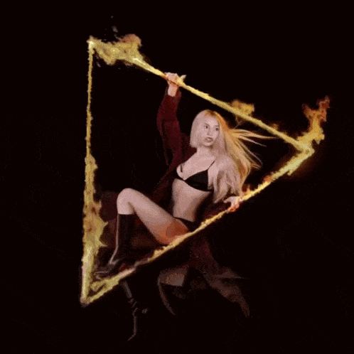a woman in a bikini is holding a triangle of fire