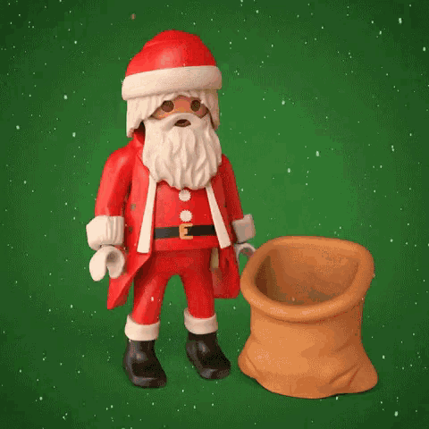 a santa claus figurine is standing next to a bag of presents