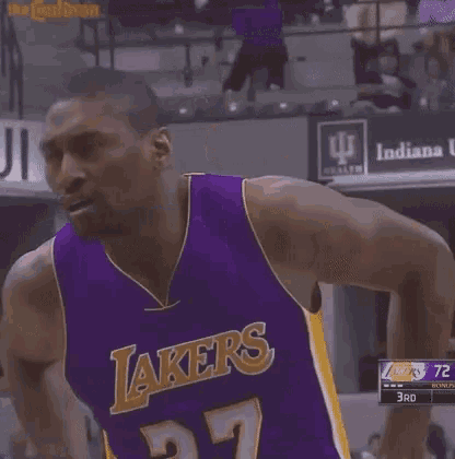 a man wearing a purple lakers jersey is standing on a court .