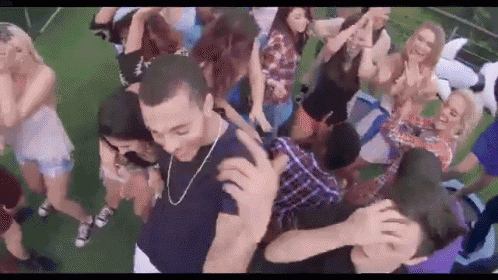 a group of people are dancing at a party and a man is holding a woman 's head .