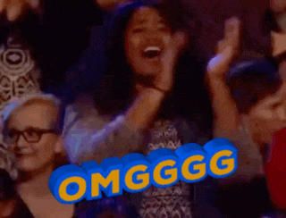 a group of people are sitting in a stadium and one of them is wearing headphones and says omg ggg
