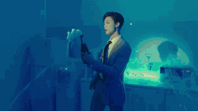 a man in a suit and tie holds a bottle of champagne
