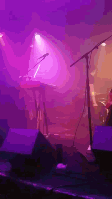 a purple stage with a keyboard and a microphone in the foreground