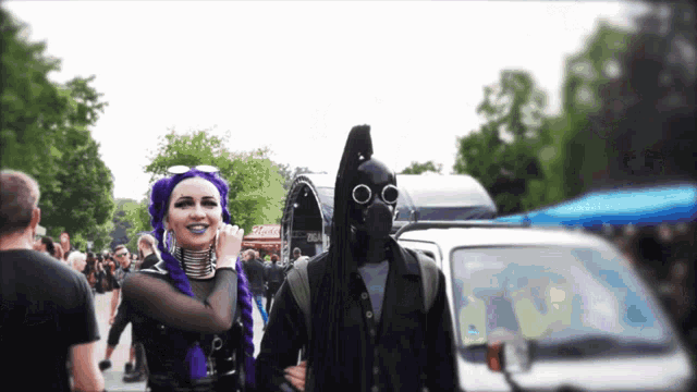 a man in a gas mask stands next to a woman