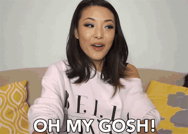 a woman is sitting on a couch and saying oh my gosh !