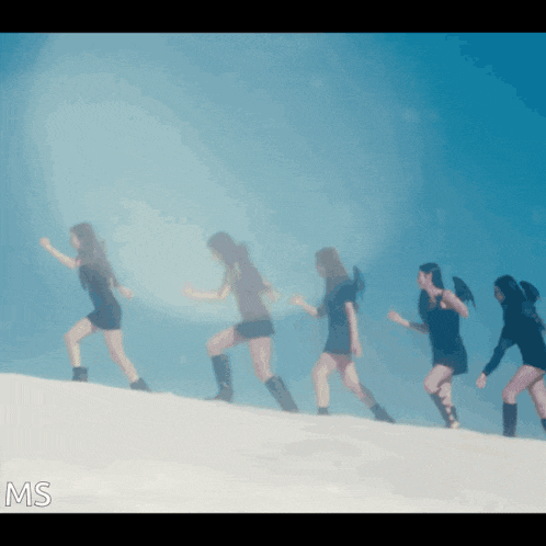 a group of women are walking up a hill and the letters ms are on the bottom right