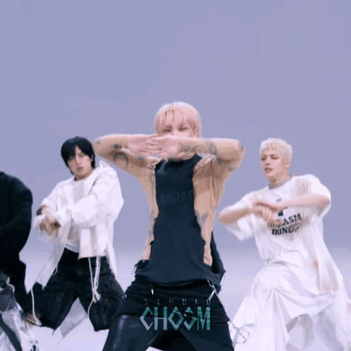 a group of young men are dancing in front of a choom sign