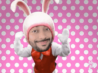 a man is wearing a bunny hat and gloves on a pink background