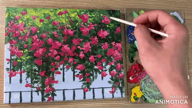 a person is painting a picture of flowers on a canvas