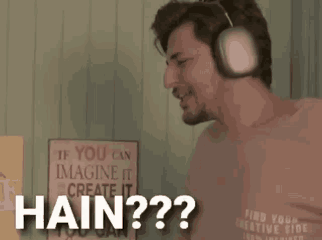 a man wearing headphones and a sign that says " if you can imagine it create it hain "