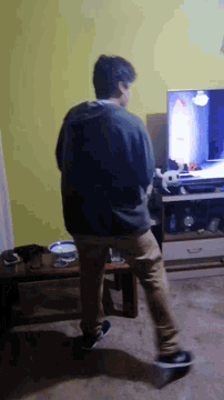 a man is standing in front of a flat screen television