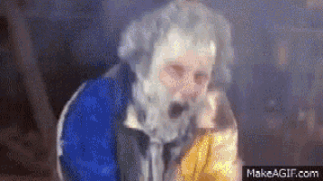 a man with a beard is wearing a blue and white jacket and smoking a cigarette .