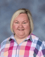 a woman wearing a plaid shirt is smiling for a picture .