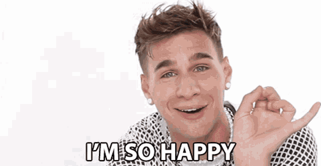 a young man is wearing a pearl necklace and earrings and says `` i 'm so happy '' .