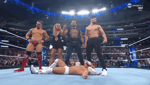 a group of wrestlers are standing in a wrestling ring with tnt sports on the screen