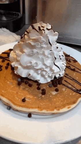 a pancake with whipped cream on top and chocolate chips