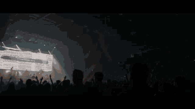 a crowd of people at a concert with a large screen behind them that says " you 're a winner "