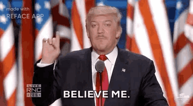 a man in a suit and tie is giving the middle finger and saying `` believe me '' while giving a speech .