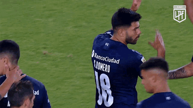 a soccer player wearing a banco ciudad jersey is giving a high five
