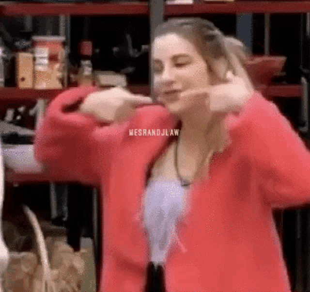 a woman in a red jacket is making a funny face
