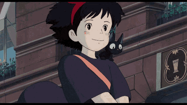a girl with a black cat on her shoulder stands in front of a building with the letter t on it