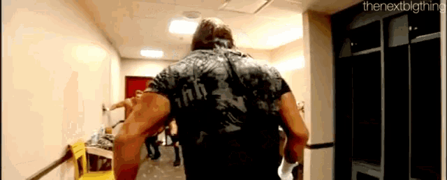 a man is walking through a locker room .