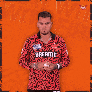 a man wearing a red shirt that says dream11 on it