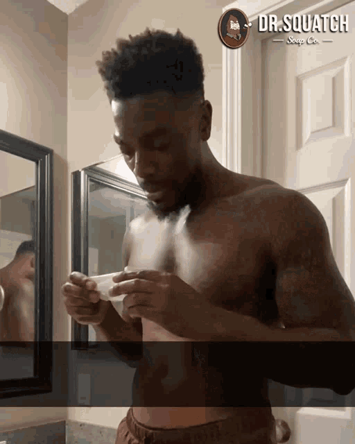 a shirtless man is looking at something in front of a door that says dr.squatch soap co.