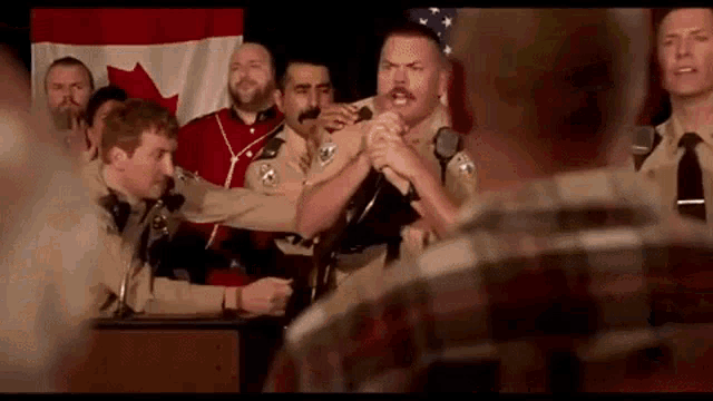 a group of police officers are standing in front of a microphone in a room .