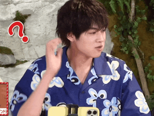 a man wearing a blue shirt with flowers and a question mark