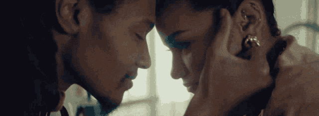a man and a woman are touching their foreheads