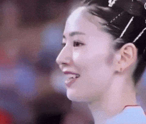 a close up of a woman 's face with her tongue out and a crown in her hair .