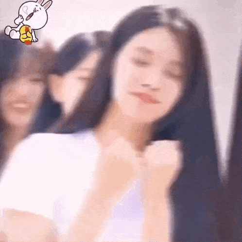 a group of girls are standing next to each other and one of them is holding a bunny .