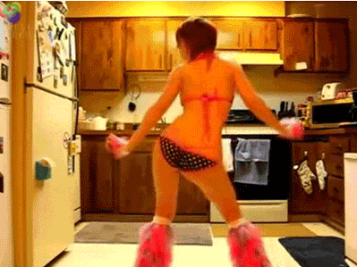 a woman in a bikini and pink boots is dancing in the kitchen