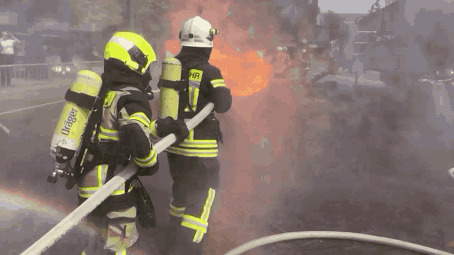a fireman wearing a helmet with the number 1 on it is spraying a hose