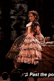 a woman in a pink dress is singing past the po