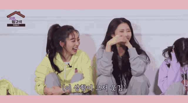 two girls are sitting next to each other and one of them is wearing a yellow hoodie that says ' strawberry ' on it