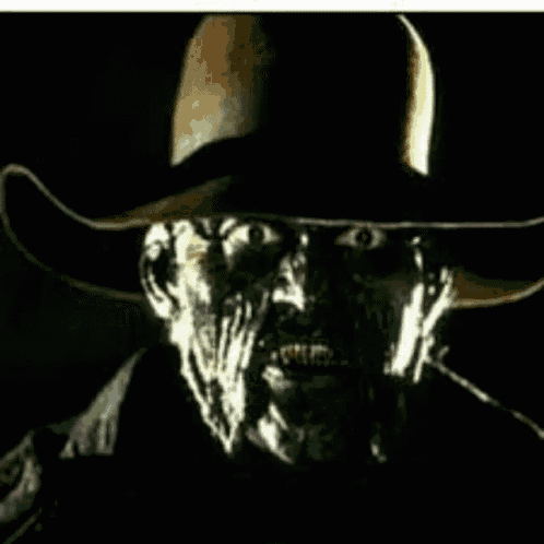 a man wearing a black cowboy hat is smiling