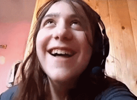a young woman wearing headphones is smiling and looking up .