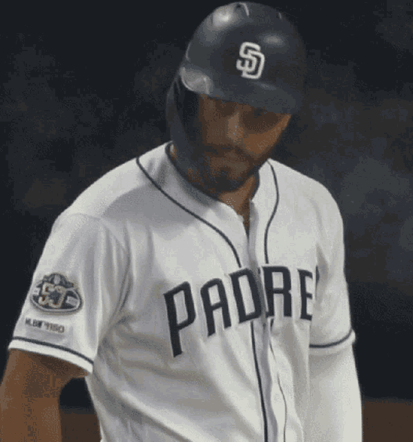 a padres baseball player wearing a black helmet and a white jersey