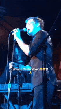 a man singing into a microphone with the words " what is dexter doing " next to him