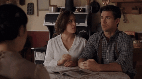 a man and a woman are sitting at a table talking