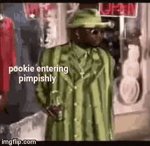 a man in a green suit and hat is standing outside of a store .