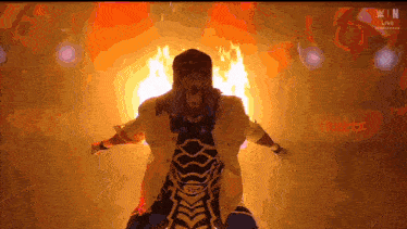 a man in a mask is standing in front of a fire and the word win is on the screen
