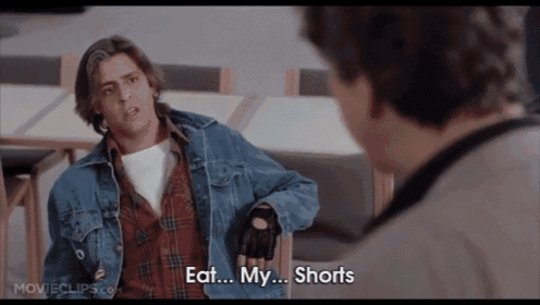a man wearing a plaid shirt and a denim jacket is talking to another man who is wearing shorts .